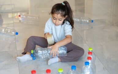 Dijete se igra s plastičnim bocama