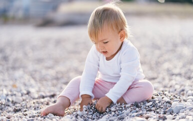 Dijete se igra s kamenčićima