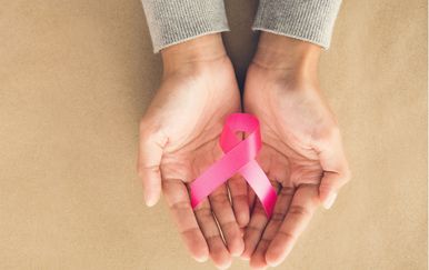 Ženske ruke drže ružičastu vrpcu, simbol borbe protiv raka dojke