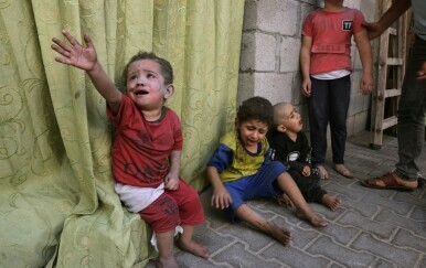 Palestinska djeca prekrivena prašinom od izraelskog zračnog napada sjede u krugu bolnice u Rafahu, u južnom pojasu Gaze