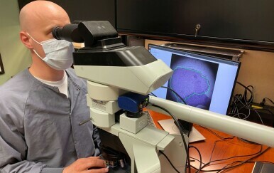 Patolog proučava uzorak tkiva kroz ARM mikroskop
