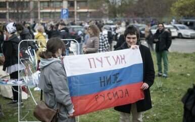 Ruski aktivisti drže zastavu na kojoj piše Putin nije Rusija tijekom prodemokratskog prosvjeda u Beogradu