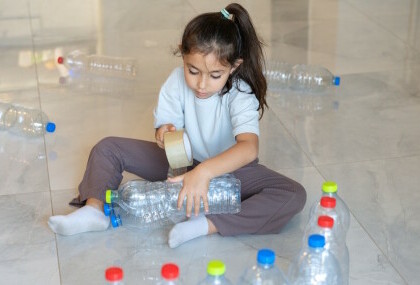 Dijete se igra s plastičnim bocama