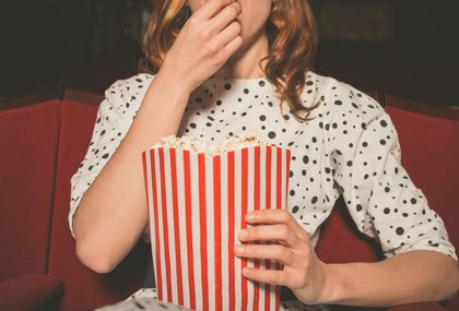 Žena u kinu jede kokice