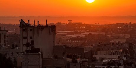 Sunce izlazi iza oštećene zgrade iznad horizonta Khan Yunisa u južnom pojasu Gaze