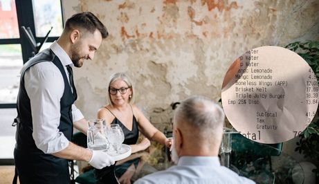 Konobar kako poslužuje ljude i račun iz restorana