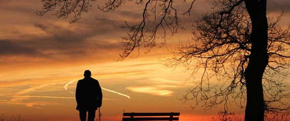 Starac usamljeno stoji i gleda zalazak sunca