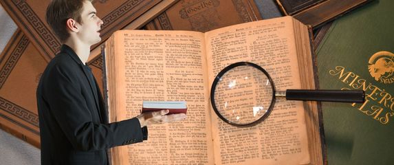 Muškarac s otvorenom knjigom i knjige s povećalom
