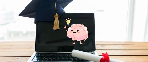 Laptop s diplomom i kapom uz grafiku mozga