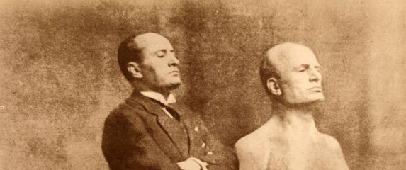 Benito Mussolini pozira uz svoju bistu