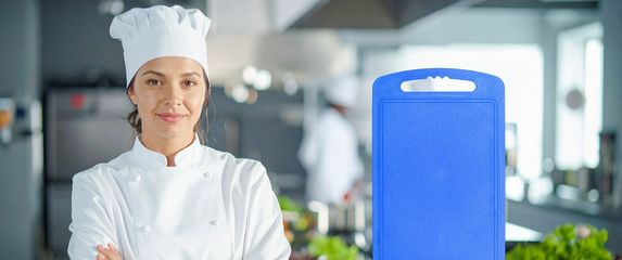 Kuharica u kuhinji i daska za rezanje