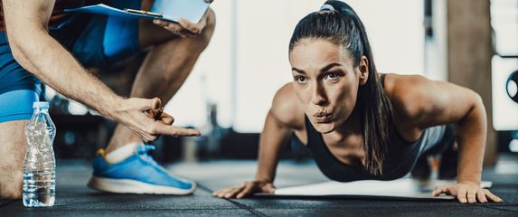 Žena koja radi sklekove u teretani