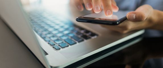 Žena koristi mobitel i laptop, ilustracija