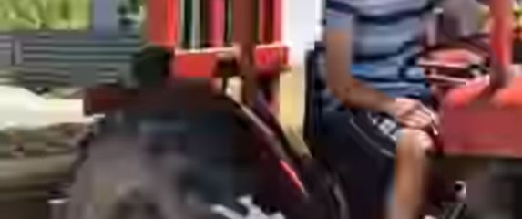 Mladić na traktoru koji prevozi kauč