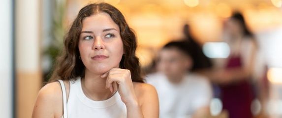 Djevojka sjedi sama u kafiću