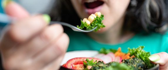 Žena jede vegansku salatu