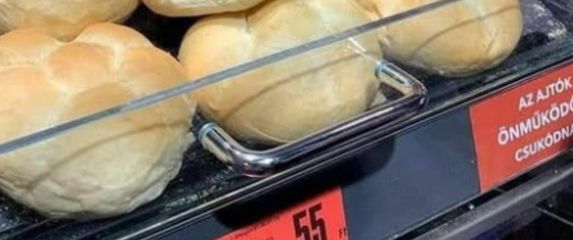 Miš koji jede pecivu u izlogu trgovine