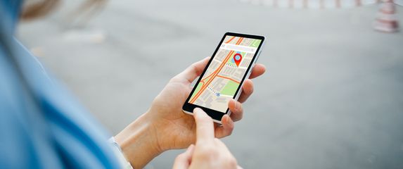 Žena koristi aplikaciju karata na mobitelu za navigaciju, ilustracija