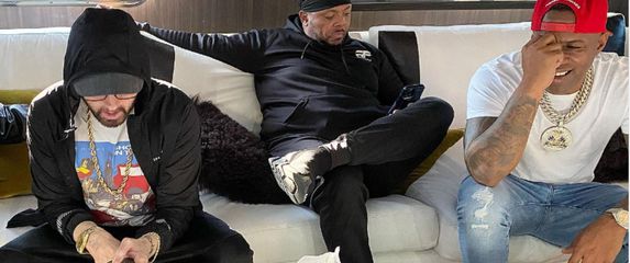 DJ Whoo Kid i reperi Eminem i Mr. Portera iz grupe D12 sjede na kauču na i gledaju na mobitel