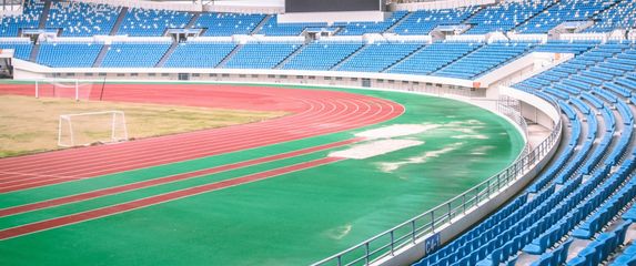 prazan stadion s atletskom stazom travom i golovima