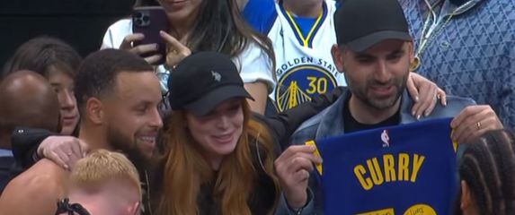 košarkaš Steph Curry i Lindsey Lohan sa suprugom Baderom Shammasom pozira za sliku s dresom Curryja i posvetom na brojevima
