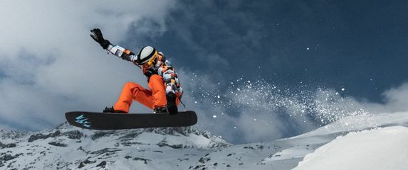 Snowboarder u letu kako izvodi trik