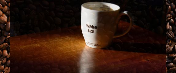 slika jutarnje šalice kave na pozadini od zrnaca kave