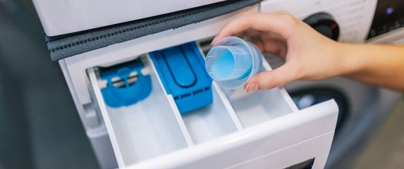 Žena stavlja omekšivač u perilicu rublja