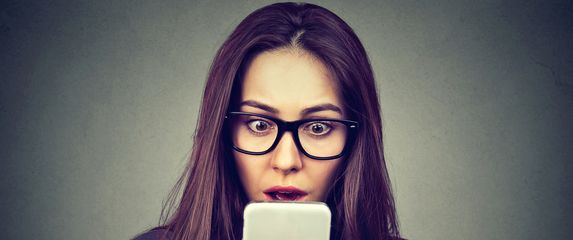Šokirana žena gleda u telefon, ilustracija