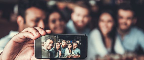 Grupna selfie slika osoba u baru