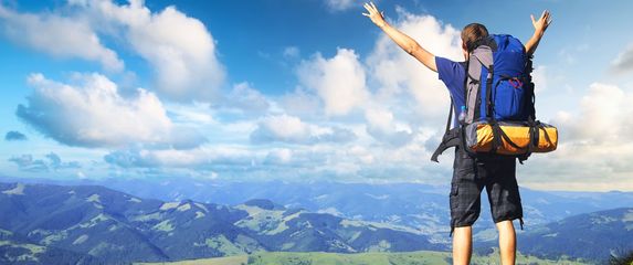 Muškarac s raširenim rukama kako gleda prema horizontu