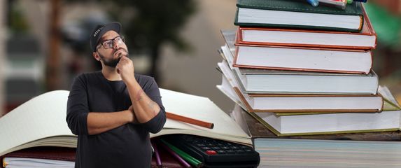 Razne knjige i pomagala u učenju uz muškarca koji razmišlja