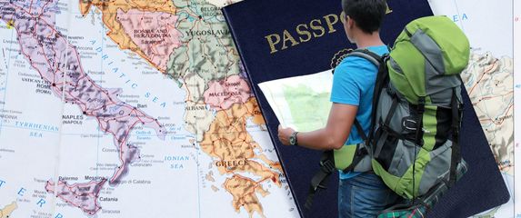 Karta Europe i turist s kartom u rukama i ruksakom na leđima