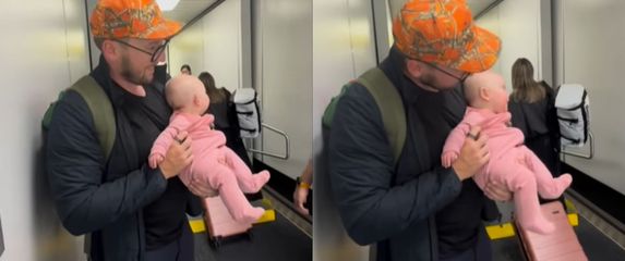 Otac koji drži bebu u rukama nakon izlaska iz zrakoplova