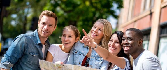 Razni turisti koji gledaju na kartu