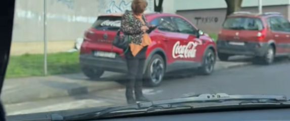 Gospođa na mobitelu nasred pješačkog prijelaza
