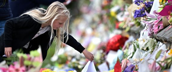 Ljudi polažu cvijeće u spomen žrtava (Foto: AFP)