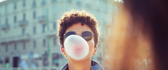 Djevojka puše balon od žvakaće gume