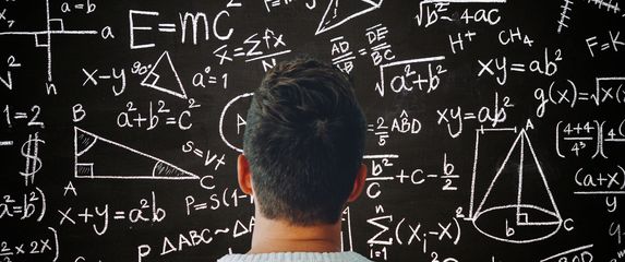 Muškarac kako razmišlja ispred ploče s matematičkim formulama