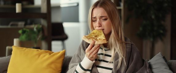 Tužna djevojka jede pizzu