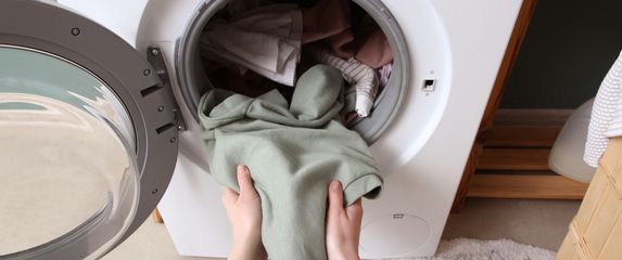 Žena stavlja rublje u perilicu