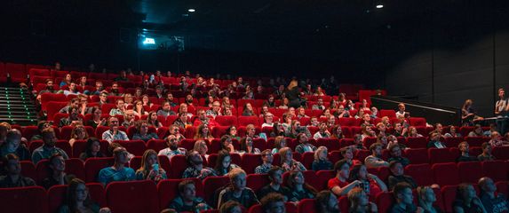 Ljudi sjede u kino dvorani i gledaju film