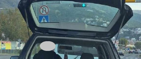 Vozač koji rukom pridržava teret koji prevozi