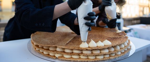 Erika i Eni dovršavaju mille-feuille tortu ispred posjetitelja festivala Jesi za tortu?