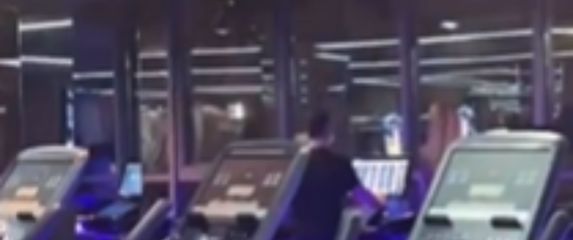 Muškarac u teretani na traci za trčanje