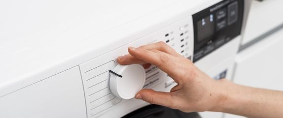 Žena namješta perilicu rublja