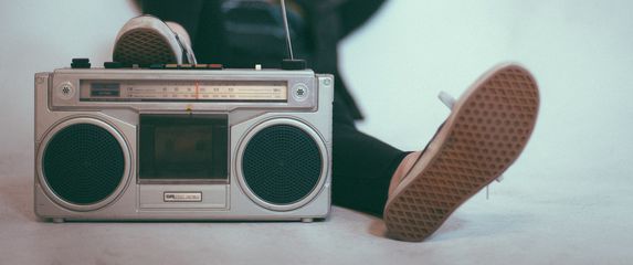 žena leži s nogom na radiju opušteno slušajući glazbu
