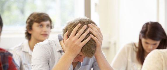 Dečko se drži za glavu