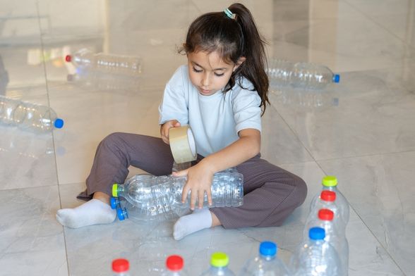 Dijete se igra s plastičnim bocama