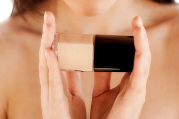 Žena drži bočicu tekućeg pudera